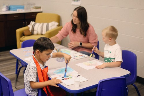 Children painting at table during Children's Church.