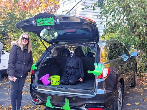 Woman standing by a decorated car trunk